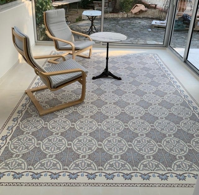 Sol en carreaux de ciment à motifs formant un tapis dans une véranda